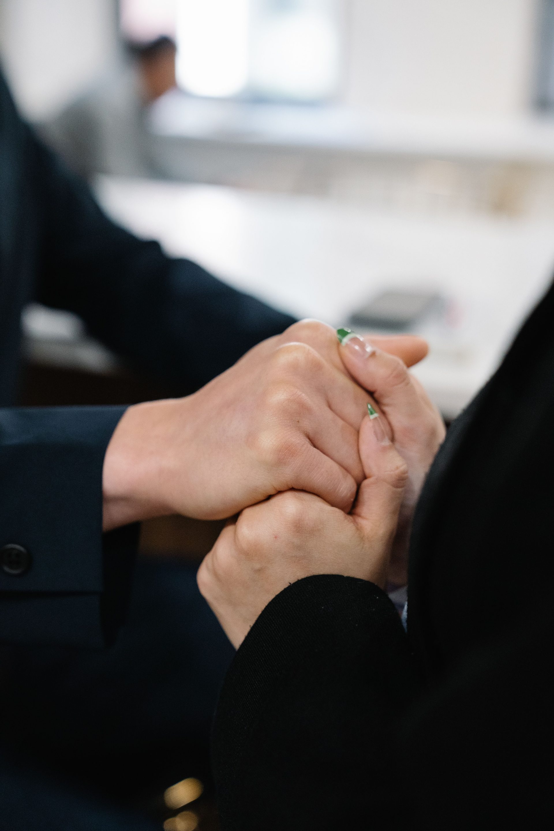 A close-up of two people holding hands, symbolizing support and affection.